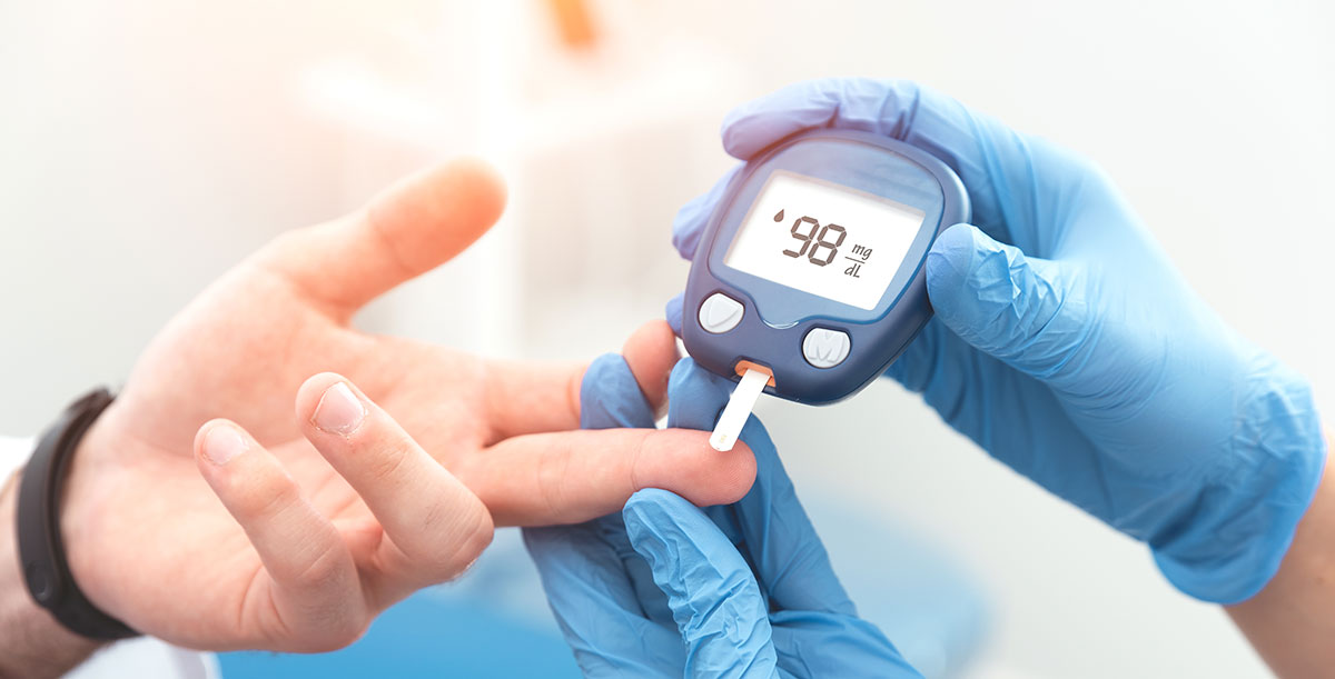 medical worker taking blood glucose level of a patient